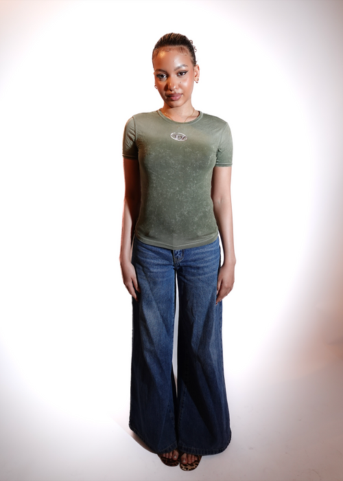 Person wearing a green t-shirt and blue jeans on a white background